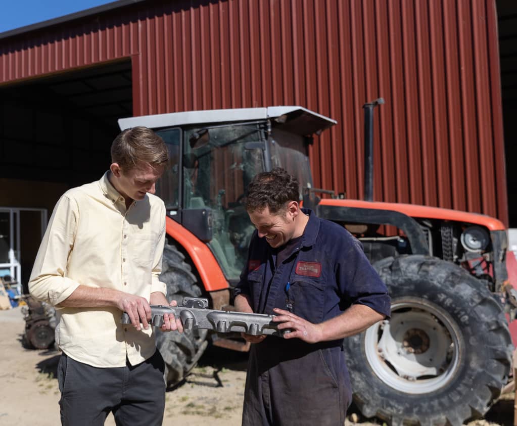 A team member shows a tractor part onsite at a customers yard