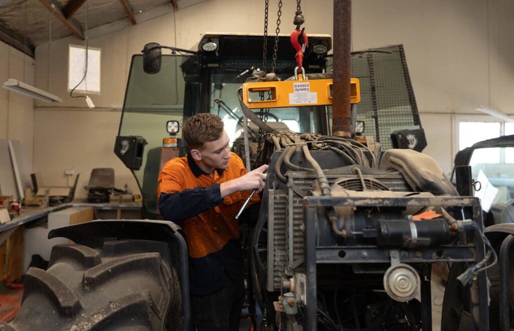 A ProPart mechanic works on a tractor for dismantling