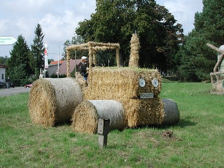Straw bale tractor with farmer on board