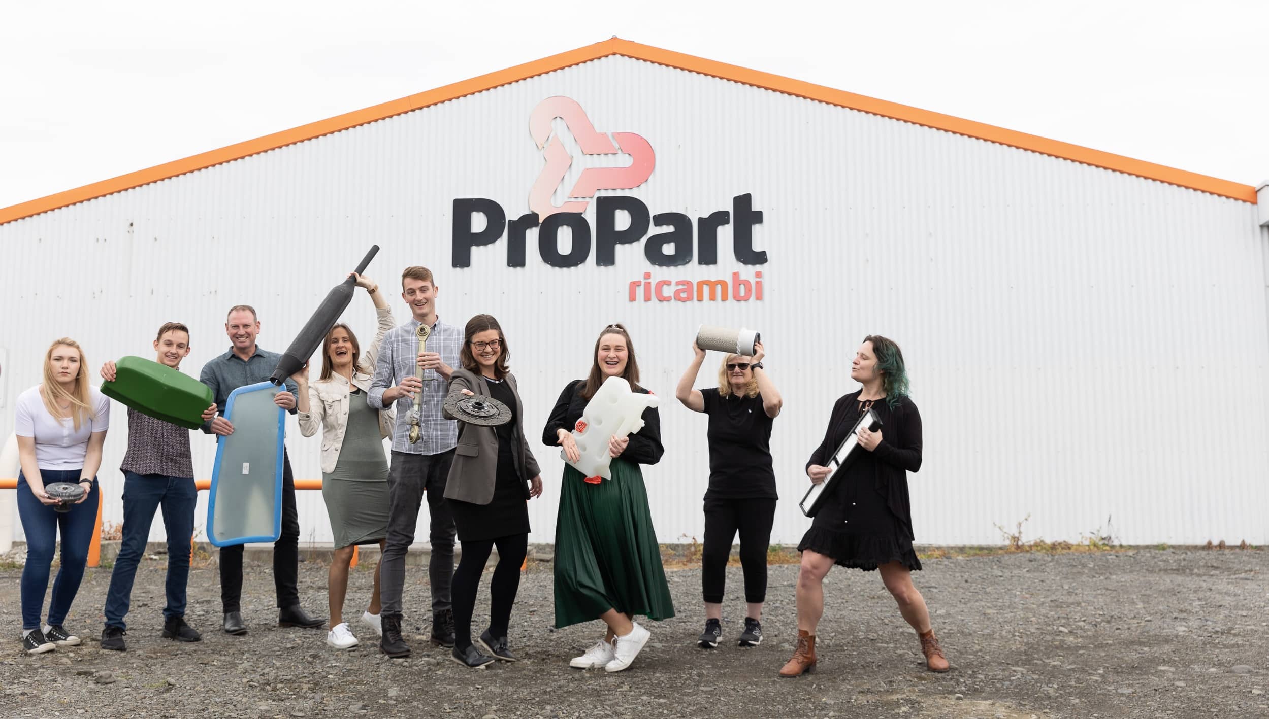 The ProPart team outside the building having fun with some tractor parts
