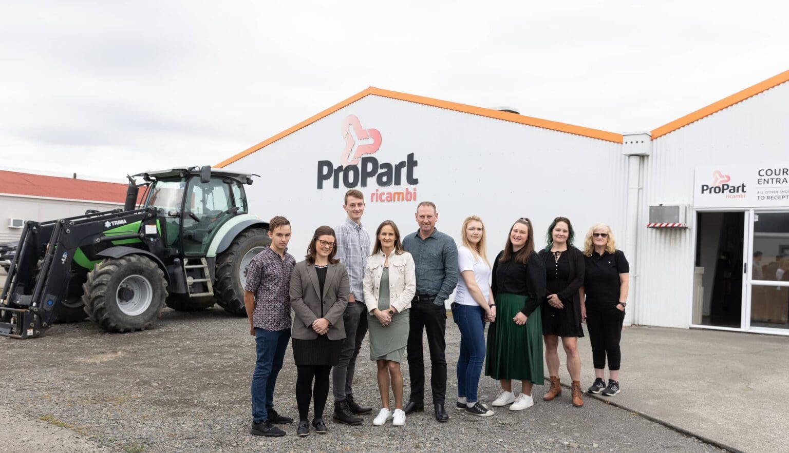 The ProPart team celebrating outside the building with tractor in background